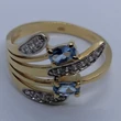 Nagyonszép világoskék köves 4 karomba foglalt, asszimetrikusan eltolt és fehér cirkon kövekkel díszített arany gyűrű