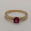 Középen 4 karomba foglalt kerek rubin színű, két oldalt fehér cirkon kővel díszített arany gyűrű