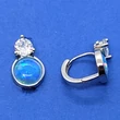 Buttonos foglalatban kék opál kő, felette kerek fehér cirkon kővel díszített ezüst karika fülbevaló