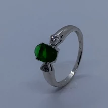 Középen ovális zöld színű cirkonkővel, és két szélen háromszög foglalatban foglalt fehér cirkon köves fehér arany gyűrű