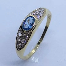 Középen nagyon szép világoskék kővel és két oldalt fehér cirkon kövekkel díszített arany gyűrű