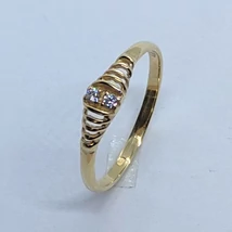 Középen fehér cirkon kővel, két oldalt áttört mintával díszített arany gyűrű