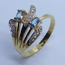 Nagyonszép világoskék köves 4 karomba foglalt, asszimetrikusan eltolt és fehér cirkon kövekkel díszített arany gyűrű