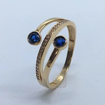 Középen sorkővel kirakott, két oldalt buttonos foglalatba foglalt kék színű cirkon kővel díszített arany gyűrű