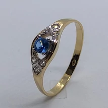 Klasszikus formájú középen 4 karomba foglalt kék topáz színű és két oldalt fehér cirkon kővel díszített arany gyűrű