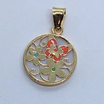 Kerek arany medál, melyet háttérként gyöngyház lappal béleltek amire színes zománccal díszitett virág minták kerültek