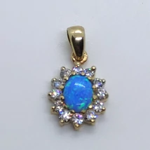 Gyönyörű ovális kék opál arany medál, amelyet karmos foglalatú cirkon kövek kereteznek