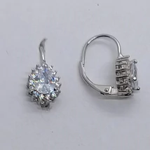 Csepp alakú fehér cirkon lő 3 karomba foglalva, szélen fehér cirkon sorkővel díszített ezüst fülbavaló