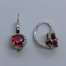 Kerek kerettel díszített négy karomba foglalt kerek rubin színü cirkon köves ezüst fülbevaló