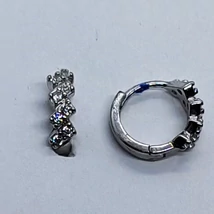 Egymástól sréen eltolt karmos foglalatú cirkon kövekkel díszített ezüst karika fülbevaló