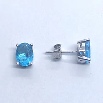 Négy karomba foglalt, ovális kék topáz színű ezüst fülbevaló