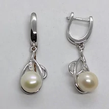 Felül sima szárrésszel alúl cirkon kővel díszített absztrakt mintába épített 7 mm-es édesvizi tenyésztett gyönggyel készített ezüst lógós fülbevaló