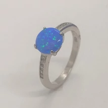 4 karomba foglalt kerek kék opállal két oldalt fehér cirkon sor kövel díszített ezüst gyűrű