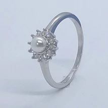 Középen 4 mm-es édesvizi tenyésztett gyöngy, karmokba foglalt cirkon kövekkel keretezett ezüst gyűrű