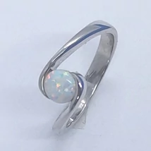 Asszimetrikusan eltolt sin részbe S alakba befogott kerek fehér opállad díszített ezüst gyűrű