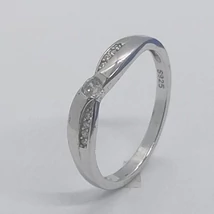 Középen leszükített fejrészű, sülyesztett kerek cirkon kövel, egymással ellentétes oldalon apró cirkon kövekkel készített eljegyzési ezüst gyűrű