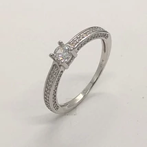 4 karomba foglalt kerek cirkon kővel díszített, és két felén három oldalas cirkon kő berakással díszített ezüst eljegyzési gyűrű