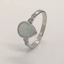 Sima foglalatba foglalt csepp alakú fehér opál, két oldalt két-két fehér cirkon kővel díszített ezüst gyűrű