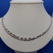 Középen kiszélesedő téglalap szemekből álló ezüst nyakék