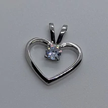 Csúsztatós erlivel ellátott középen 4 karomba foglalt gyémánt csiszolású szív ezüst medál