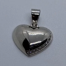 Színén domború, viszálíán homorú egyik oldalon apró sor cirkon kővel díszített szív ezüst medál