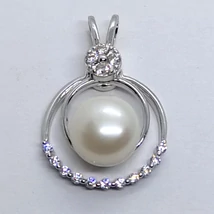 10 mm-es édesvizi tenyésztett gyönggel, dupla karikával, és fehér cirkon sorkővel kirakott, fix erlivel készített ezüst medál, melynek belső marikája mobil