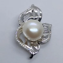 Áttört szirmú, cirkon sorkővel díszített Lótusz virágra emlékeztető, csúsztatós erlivel ellátott ezüst medál, melynek közepébe egy 10 mm-es édesvizi tenyésztett gyöngyöt rögzítettek