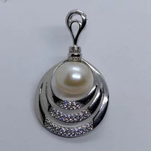 Apró fehér cirkon kővekkel díszített 3 soros kerek, csúsztatós erlivel ellátott ezüst medál, melyet 10 mm-es édesvizi tenyésztett gyönggyel kombináltak