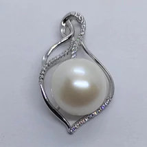 Fehér cirkon sorkövekkel díszített körte alakú hullámos vonalú csúsztatott erlivel ellátott ezüst medál, melyre gyönyörű 14  mm-es nagyságú édesvizi tenyésztett gyöngyöt rögzítettek